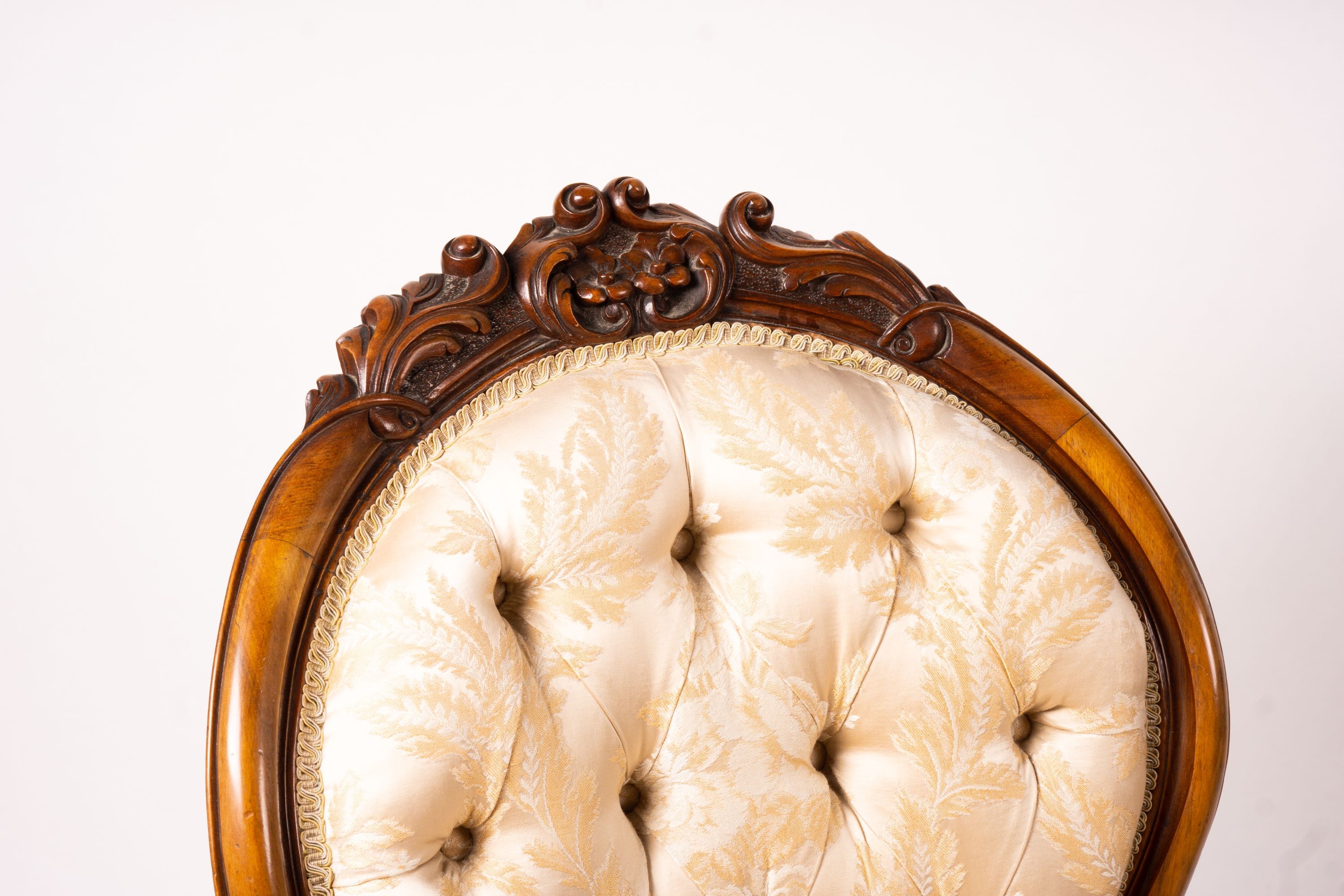 A late Victorian carved walnut three piece salon suite, comprising chaise longue, open armchair and nursing chair